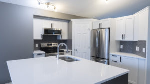 kitchen-renovation-edmonton-alberta-white-cabinets-and-white-countertops-with-grey-tile-stainless-steel-appliances