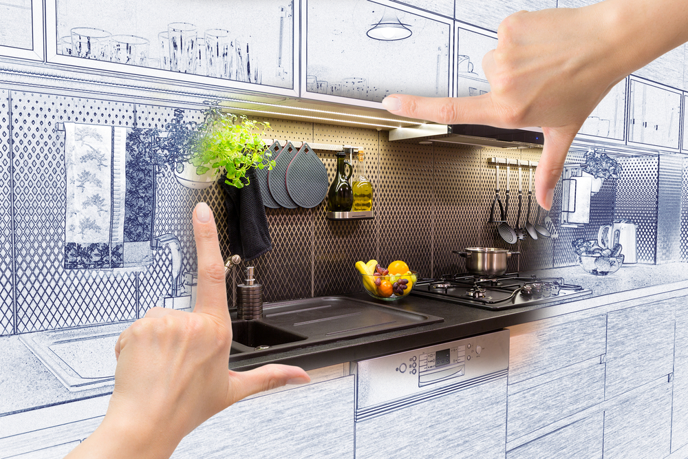 Female hands framing custom kitchen design. Combination drawing and photo.
