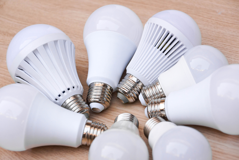 Different types of LED light bulbs on wooden background