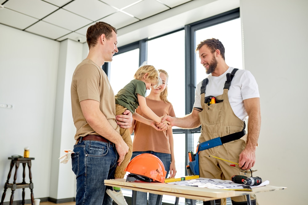 family discussing renovation with contractor, child shaking contractor's hand