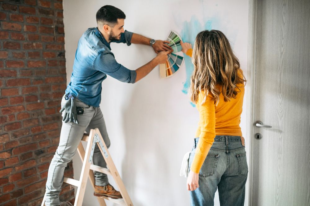 Couple painting home walls together