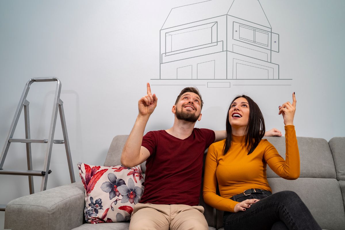 man and woman sitting on sofa dreaming about the perfect home