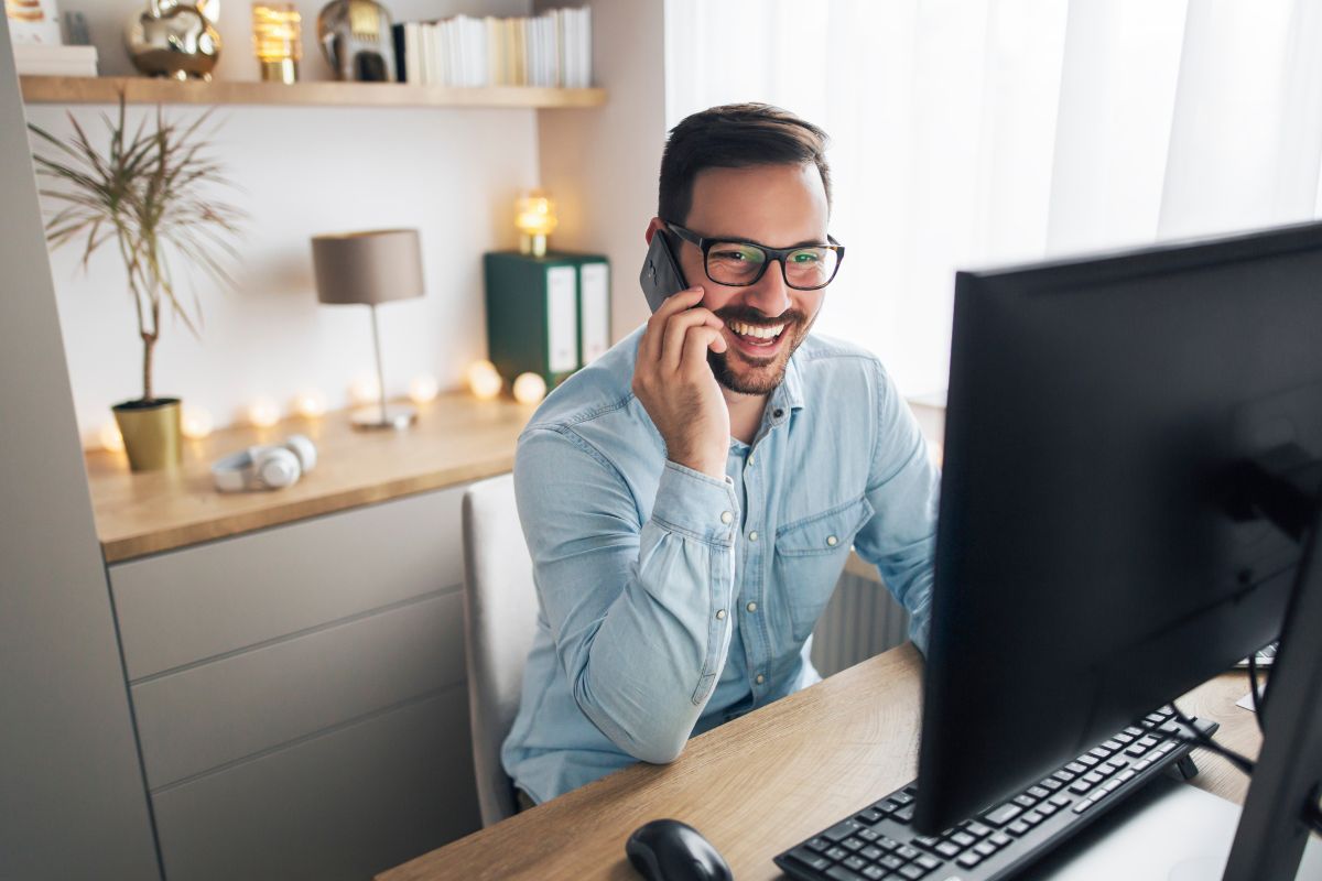 smiling freelancer working remotely from home talking on the phone