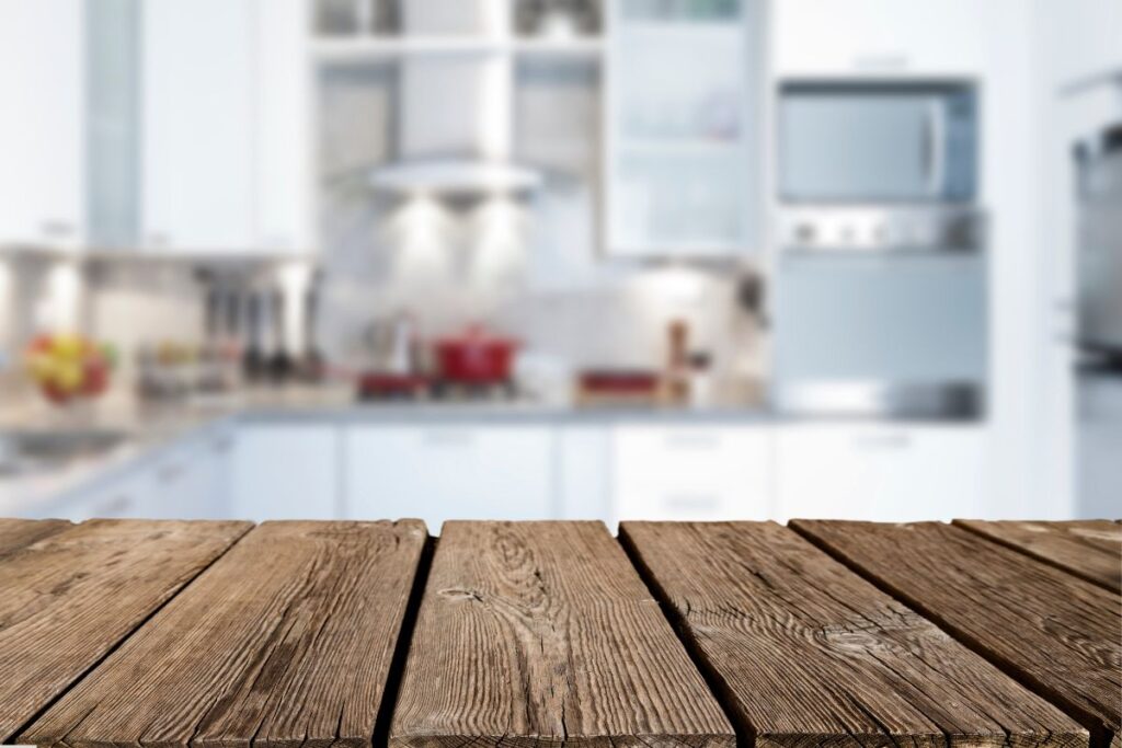 empty rustic wood kitchen counter-top with modern kitchen in the background